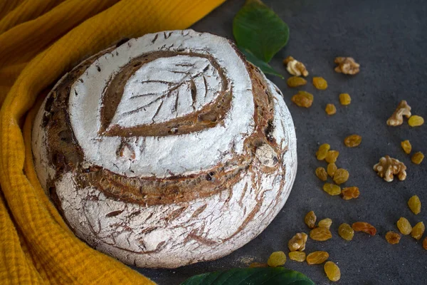 Beautiful rye sourdough bread on a table. Homemade bread made of whole grain. Healthy living concept. Crusty bread on a yellow kitchen towel. Top view photo of fresh baked sourdough bread.