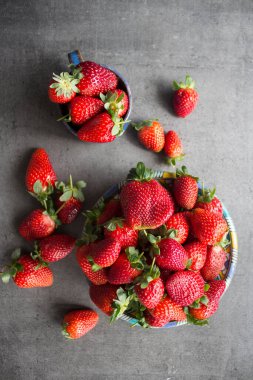 Gri masada taze çilek. Sulu yaz meyvelerinin en iyi görüntüsü. Taze konsept yemek.. 
