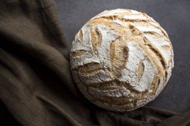 Gri arka planda, kopyalama alanı olan bir zanaatkar ekmeği. Ev yapımı ekşi ekmek tarifleri. Sağlıklı yeme kavramı.