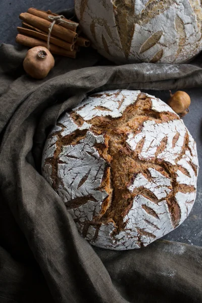 Round sourdough bread on a table. Crusty loaf texture close up. Top view photo of freshly baked artisan bread. Gray textured background. Healthy eating concept.