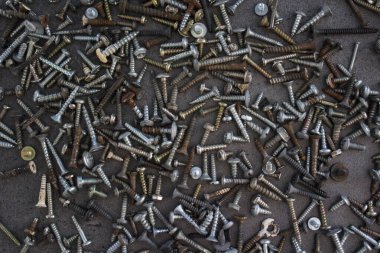 Gri beton masada bir sürü paslı somun ve cıvata var. Soyut sanayi geçmişi. 