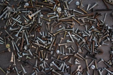 Gri beton masada bir sürü paslı somun ve cıvata var. Soyut sanayi geçmişi. 
