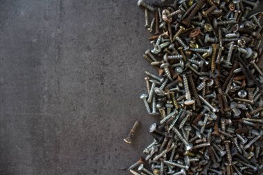 Gri beton zemin üzerinde paslı cıvatalardan yapılmış çerçeve veya sınır kopyalama alanı ile. 