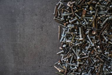 Gri beton zemin üzerinde paslı cıvatalardan yapılmış çerçeve veya sınır kopyalama alanı ile. 