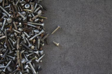 Gri beton masada bir sürü paslı somun ve cıvata var. Soyut sanayi geçmişi. 