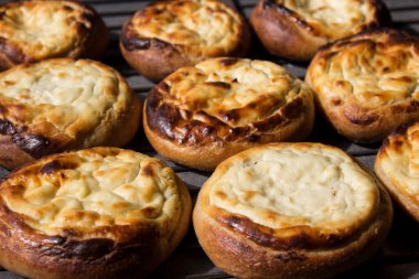 Süzme peynirli açık turtalar. Geleneksel Rus pastanesi. Taze fırınlanmış hamur işleri üst görünüm fotoğrafı.  