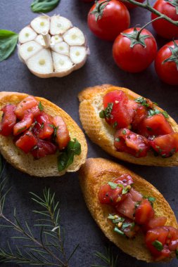 Kızarmış domatesli İtalyan bruschetta, fesleğen ve sarımsak. Lezzetli tostun en iyi görüntüsü. Sağlıklı yeme kavramı. 