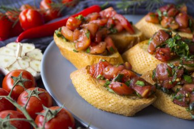 Kızarmış domatesli İtalyan bruschetta, fesleğen ve sarımsak. Lezzetli tostun en iyi görüntüsü. Sağlıklı yeme kavramı. 