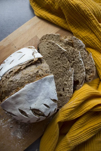 黄色のキッチンタオルの上にパンのクラスト 焼きたての生地パンのトップビュー — ストック写真