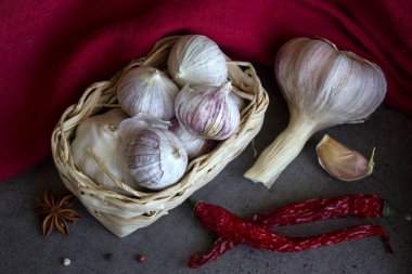 Baharatlar masada olacak. Sarımsaklı hayat. İki çeşit sarımsak, kırmızı biber ve keten kumaş..  