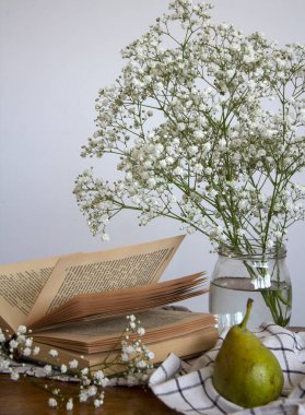 Bir fincan çayla sakin bir hayat. Üzerinde küçük beyaz çiçekler ve bir fincan siyah çay olan basit kompozisyon fotoğrafı. Güzel sabah resmi..