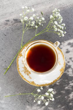 Bir fincan siyah çay ve beyaz çiçeklerle sade bir hayat.. 