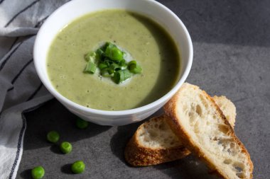 Vejetaryen çorbasını bir kasede yakın plan çek. Soğanlı yeşil bezelye kremalı çorba. Sağlıklı yeme kavramı. 