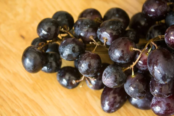 桌上放着黑葡萄夏季新鲜水果的头像 美丽的葡萄近照照片 葡萄上有水滴 吃新鲜的概念 — 图库照片