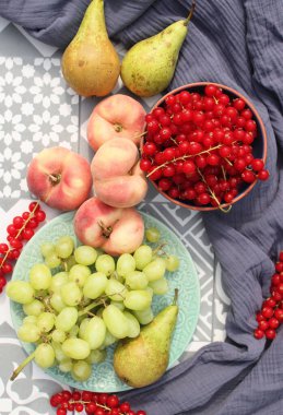 Fresh fruits and berries on a table. Top view photo of blueberry, grapes, pears and peaches. Summer food close up photo. Eating fresh concept. 