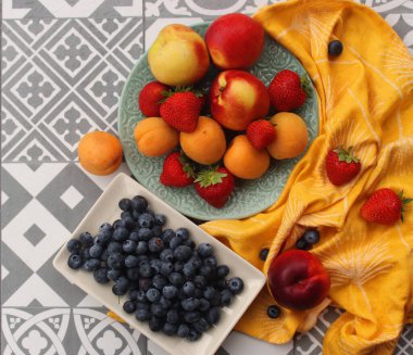 Masadaki taze meyveler. Organik sulu yaz meyveleri ve meyveleri. Nektarin, kayısı, çilek, yaban mersini. Sağlıklı beslenme konsepti. Dengeli diyet. 