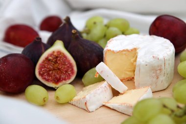 Tahtada peynir ve taze meyve var. Sofrada sulu incir, üzüm ve erik var. Gurme yemekleri.. 