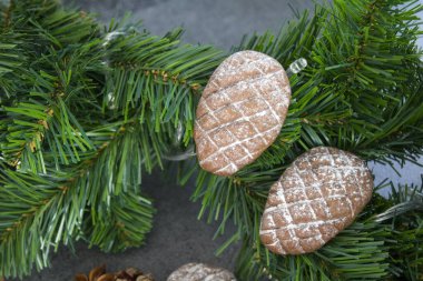 Koyu gri desenli arka planda Noel bisküvileri. Kurabiye, tarçın, anason ve festival dekorasyonlarının en üstteki görüntüsü. 