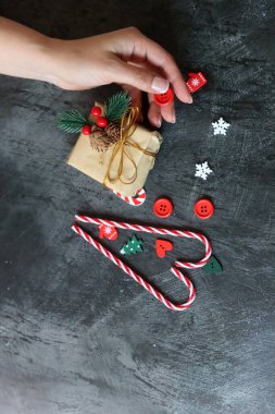 Noel süsleriyle dolu bir hayat. Paketlenmiş bir hediyenin, kırmızı popoların, koyu arkaplanlı baston şekerlerin fotokopi çekilen fotoğrafını çek.. 