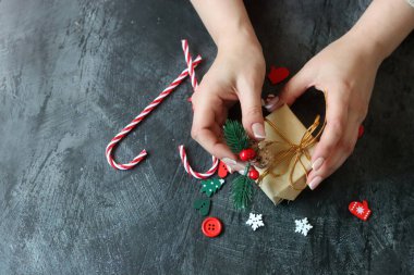 Noel süsleriyle dolu bir hayat. Paketlenmiş bir hediyenin, kırmızı popoların, koyu arkaplanlı baston şekerlerin fotokopi çekilen fotoğrafını çek.. 