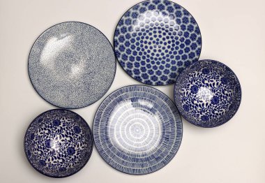 Arka planda mavi seramik tabaklar ve kaseler var. Seramik sofra takımı kapat.