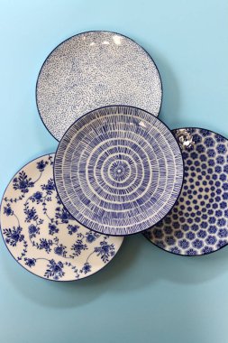 Arka planda mavi seramik tabaklar ve kaseler var. Seramik sofra takımı kapat.