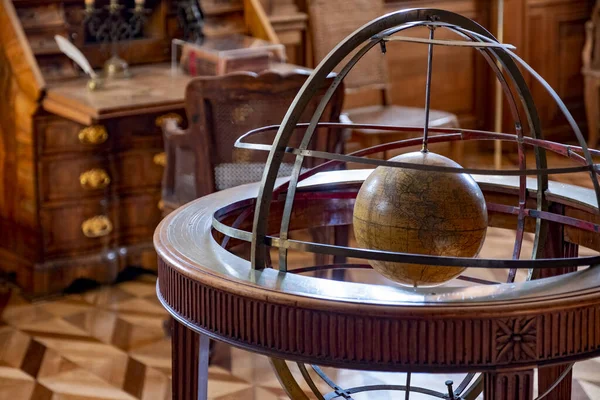 Eski kabinedeki büyük ahşap astronomik küre. Değerli ahşaptan yapılmış antik bir bilimsel alet. Bir bilim adamının dolabı, antika ahşap iç mekan..