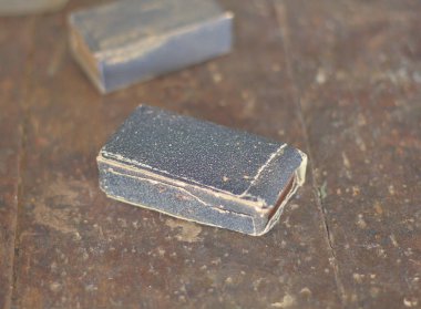 Gri zımpara kağıdı eski kırmızı ahşap zemine yakın. İki ahşap zımpara kağıdı..