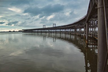 Metal yapı ve ahşap zemin köprüsü okyanus üzerinde.