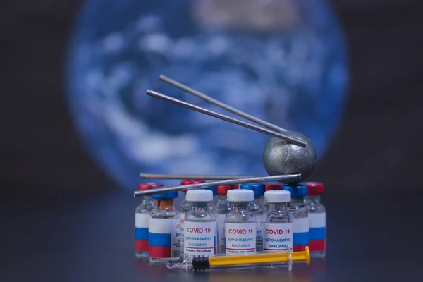 Group of russian vaccines named after a well-known russian satellite against Covid 19 virus and syringe. With background of planet earth and out of focus. Tag text reads, corona virus injection only.