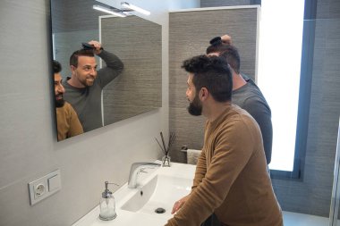 Gay, evlerinin banyosunda sarılıp saçlarını çok sevecen bir şekilde tarıyor. Aile çeşitliliği.