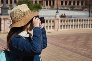 Genç ve güzel Asyalı turist, seyahati sırasında refleks kamerayla anıtın fotoğraflarını çekiyor..