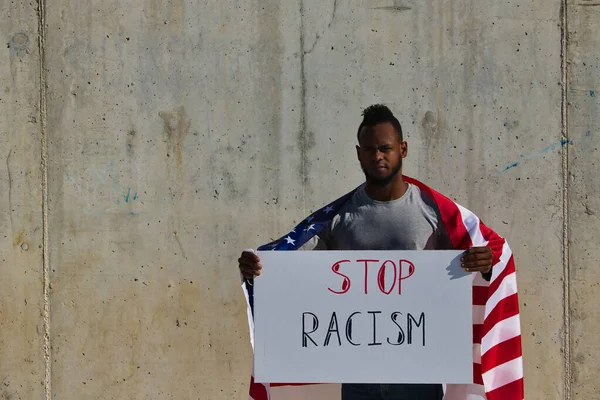 アフリカ系アメリカ人の男性は肩に旗を掲げて国旗を掲げている 人種差別をやめ — ストック写真