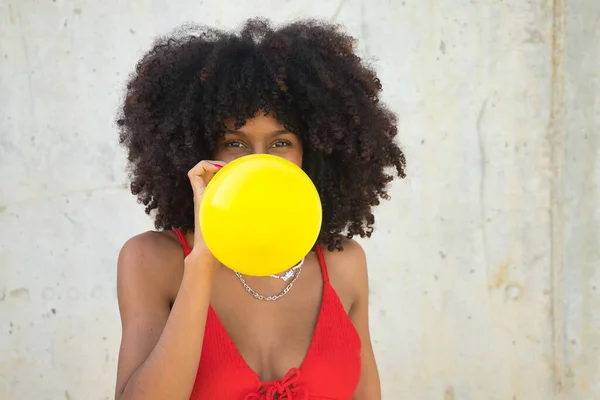 Giovane Bella Donna Afroamericana Gonfiare Palloncino Giallo Uno Sfondo Grigio — Foto Stock