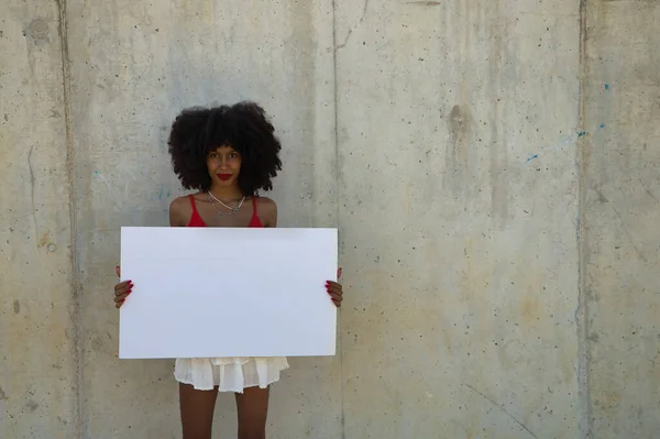 灰色のセメントの背景に白い旗を持つ若い 美しいアフリカ系アメリカ人女性 — ストック写真