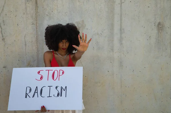 美丽的非洲裔美国妇女 高举横幅 站在灰色水泥背景上与种族主义作斗争 — 图库照片