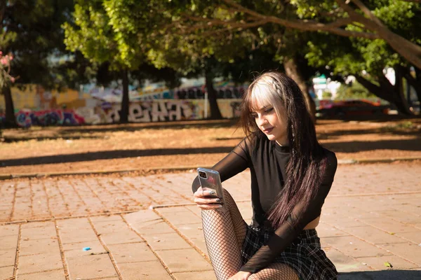 Mladá Hezká Dívka Punk Styl Sedí Obrubníku Zamyšleně Kontrolovat Sociální — Stock fotografie