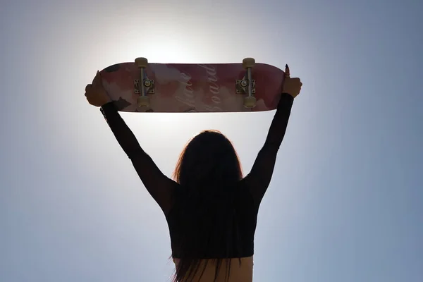 Mladá Dívka Punk Styl Zvedání Skateboard Nad Hlavu Dívá Dozadu — Stock fotografie