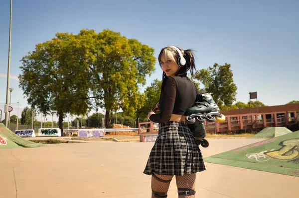 Mladá Dívka Copánky Punkovým Stylem Bílými Sluchátky Inline Bruslemi Zavěšenými — Stock fotografie