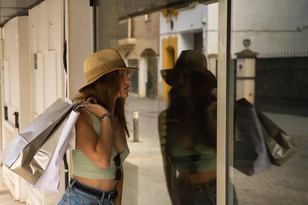Omzunda Şapka Alışveriş Torbaları Olan Genç Bir Kadın Bir Mağazanın — Stok fotoğraf