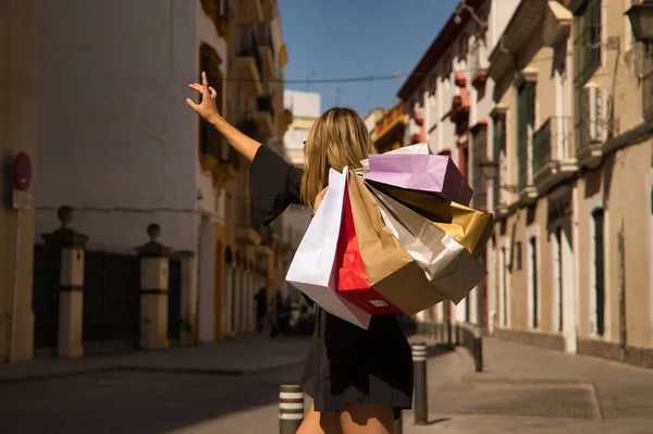 Jovem Com Sacos Compras Ombro Levantando Braço Para Parar Táxi — Fotografia de Stock