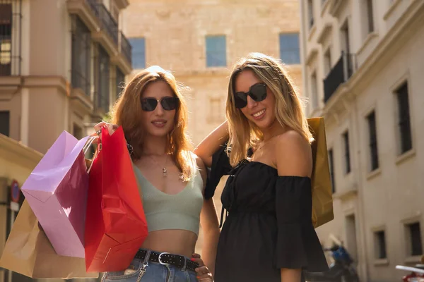 Portret Dwóch Młodych Kobiet Okularach Przeciwsłonecznych Torbach Zakupy Dłoniach Bardzo — Zdjęcie stockowe