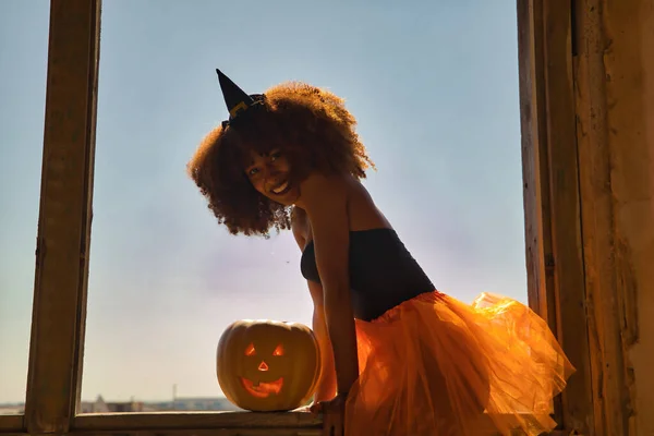 Fiatal Latin Öltözött Boszorkány Egy Ablakkeretben Egy Halloween Tök Mellette — Stock Fotó