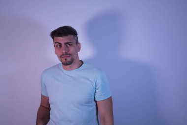 Bir gözü açık ve kaşları beyaz arka planda olan Latin kökenli genç bir erkek..