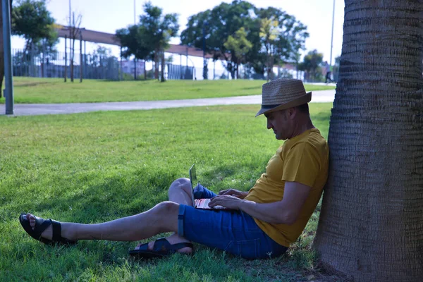 Spanischer Reifer Erwachsener Mann Sitzt Auf Einer Parkwiese Und Lehnt — Stockfoto