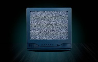 Masanın önünde eski bir televizyon alıcısı. Gradyan yeşil duvar arkaplanı, perspektif ahşap zemin üzerinde kesilmiş eski bir televizyon, mavi parıltı ve koyu ton tarzı.