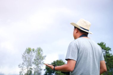 Genç adam bir tablet taşıyor. Seyahat bilgilerine bak.