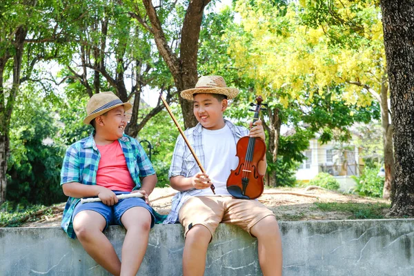 高兴的是 两个男孩在后院笑着 弹奏着音乐 小提琴和长笛 — 图库照片