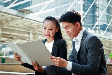 Erkek ve kadın ofis çalışanları dışarıda oturup planlama hakkında konuşurlar..