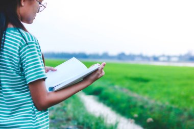 Asyalı çocuklar okumak ve öğrenmek için beyaz bir kitap açarlar..